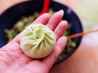 15、双色西葫芦韭菜生煎包,捏褶子收口，包成圆形的包子即可。