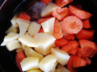 12、筋头巴脑锅,放入切好的土豆块和胡萝卜块，煮至开锅。