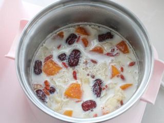 7、木瓜炖牛奶,倒入牛奶和洗净的枸杞搅拌均匀,煮两分钟关火即可。