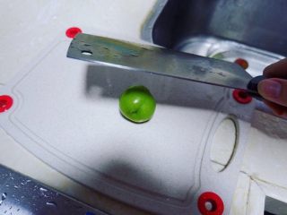 3、潮汕毂（ka）蜡李,像拍蒜头一样拍碎李子。把李子放在砧板上，用刀背一面拍下，圆溜溜的李子可能会溜走，因此还需要掌握好这个力度。