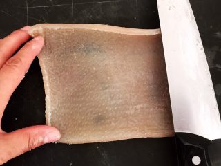 6、自制猪皮冻,用刀刮去猪皮里面的脂肪