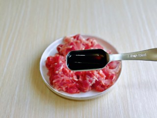 3、芦笋炒肉片,再加入一勺生抽提鲜。