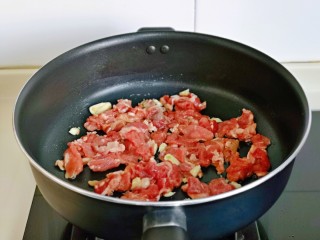 8、芦笋炒肉片,起油锅,加入切好的蒜末煸炒出香味,再加入腌制好的牛肉。