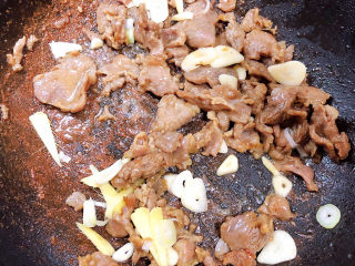 12、西兰花炒牛肉,加入葱姜蒜翻炒均匀。