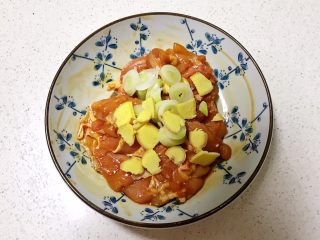 7、蒜香鸡腿,用手抓匀后加入蒜片，葱花和姜片