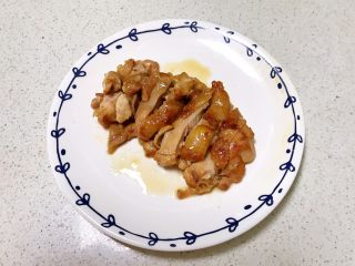 13、蒜香鸡腿,把煎好的鸡腿夹出来放入盘里，把煎好的鸡腿切成小段