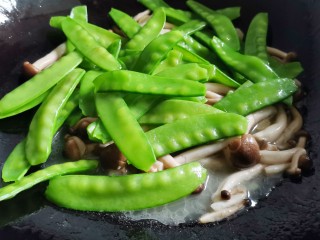 9、荷兰豆炒菌菇,倒入荷兰豆快速炒匀