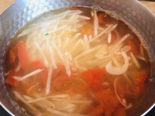 7、萝卜丝汤,待水开后放入擦好的白萝卜丝继续煮开。