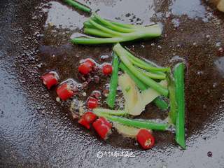 3、蒜苗肉片,放入小米椒、葱姜蒜爆香