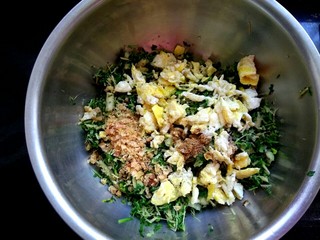 13、玉米面荠菜鸡蛋馅煎饺,把鸡蛋海米放入荠菜中,加入适量五香粉,适量盐,适量植物油