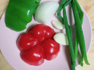 1、铁板日本豆腐,准备好蔬菜，红椒、青椒、洋葱、小葱、蒜。
