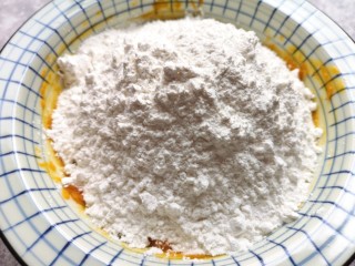 5、南瓜芝麻球,加入糯米粉,先用筷子搅拌成絮状。