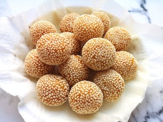 14、南瓜芝麻球,盘子里铺上厨房用纸,放上炸好的南瓜芝麻球,吸一吸多余的油分。
