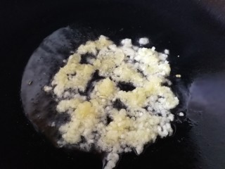 4、清蒸生蚝,锅内倒入适量玉米油，放入三分之二蒜泥，小火炒香。