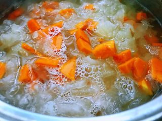 3、银耳南瓜羹,银耳煮20分钟后加入处理好的南瓜继续煮20分钟，中途可拿勺子搅动一下锅中。