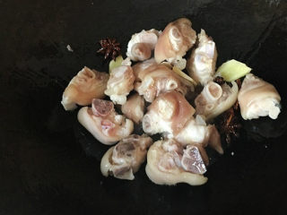 3、红烧猪蹄,加入姜片、八角、桂皮爆香，再下猪蹄料酒翻炒均匀；