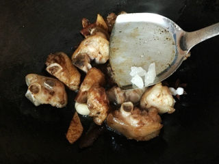 4、红烧猪蹄,加入冰糖、生抽均匀翻炒，加入辣椒大蒜；