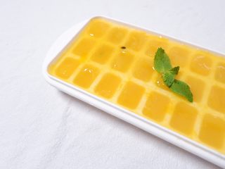 2、续命香芒百香果冰格吃法,取一冰格，每个冰格倒入1/2的果酱，再倒入1/2的矿泉水，搅拌均匀后放入冰箱冷冻，冷冻后取出就是这样啦