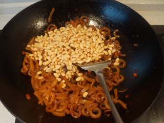 8、香辣猪皮黄豆,放入猪皮翻炒两分钟，加入生抽，料酒炒匀，倒入黄豆翻炒均匀。