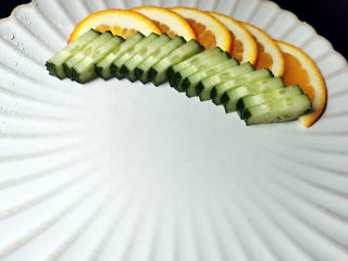 23、橙香红糟鸭脯,成品盘中码上橙与黄瓜，再把鸭脯放上，淋上橙丁