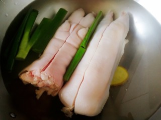 2、五香卤猪蹄,猪蹄对半切（只切开肉皮），冷水下锅，放入姜片和葱段。