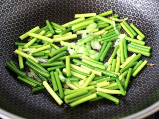 7、香脆椒爆蒜苔鸡肝,锅烧热后倒入花生油烧热,先爆香葱姜丝,再放入蒜苔,大火快速翻炒均匀。