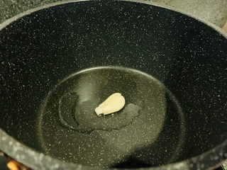 7、炒牛肝菌,放入蒜瓣，大火烧热；