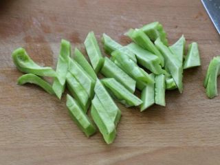 2、蛋黄焗苦瓜,将苦瓜洗净后从中间一分为二,用勺子挖去内瓤,然后切成菱形块。