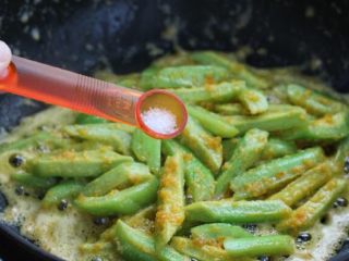 7、蛋黄焗苦瓜,苦瓜提前捞出沥水,放入锅中改大火快速翻炒一分钟,待苦瓜均匀的裹上蛋黄,按照个人口味调盐。