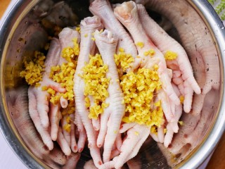 2、史上最简单的懒人电饭煲鸡爪,将鸡爪放入容器中，加入姜末。