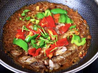 14、酱焖黄鱼粉条,大火烧开，看见青红辣椒断生变色即可关火，撒上香菜段就可以了。