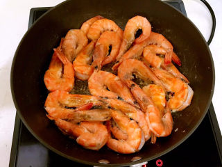 15、明虾煲,炒锅烧热后加入大豆色拉油,油烧热后加入大明虾,煎至明虾变成红色