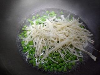 8、翡翠蛋花肉,锅内放入适量热水,放入豌豆米。金针菇。加入适量色拉油。盐,鸡精,白胡椒粉。煮下。