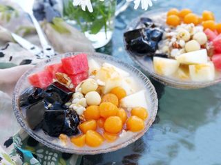 13、百变水果 八宝芋圆烧仙草,好了，现在我们就可以组装了，舀几勺银耳莲子汤到碗中，加几块甜瓜、几块西瓜、几块烧仙草，一勺子芋圆，浇些蜂蜜或蜜糖水，再撒些坚果，好了八宝芋圆烧仙草就完成了，请你享用。