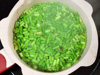 5、肉末炒蒜苔,加入少许清水。