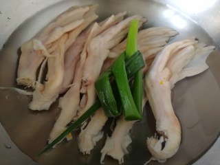 3、卤鸭掌,冷水下锅，放入小葱。