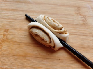 12、红糖花卷,取一个面剂，用筷子从面剂中间往下压到底。