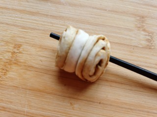 13、红糖花卷,用手捏住面团两头轻轻拉长，然后把两端向后翻折压在下边，这样一个简单的花卷就做成了。