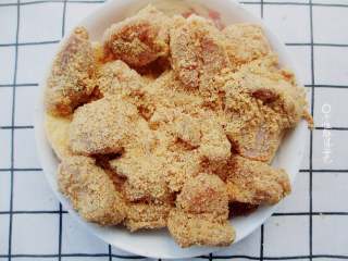 5、粉蒸排骨,把腌制好的肉排放在蒸肉粉里裹一圈，让蒸肉米粉能均匀的裹上排骨。拌好米粉的排骨均匀摆放在土豆的上层