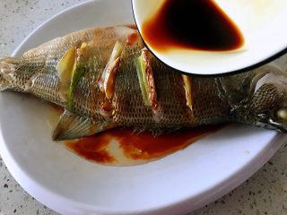 8、清蒸鲈鱼#年年有余#,把盘中蒸出来的水倒掉，浇上蒸鱼豉油。（鱼汁里带有鱼腥味）
