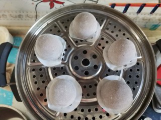 12、纯手工黑芝麻馒头,垫上油纸放入蒸屉，水烧开，进行二次发酵10分钟，发酵的时候不开火