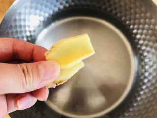 5、卤鸡翅尖,姜片去皮洗净放入锅中。