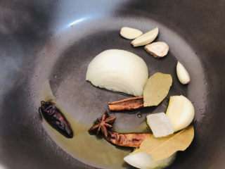 9、卤鸡翅尖,砂锅中倒入适量食用油，然后放入洋葱、八角、香叶、蒜瓣、冰糖、干辣椒、桂皮、白芷炒出香味。