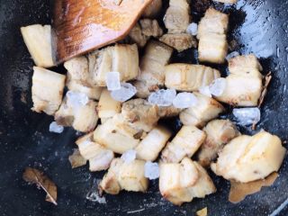 8、解腻鲜果红烧肉,下入冰糖炒制糖色，使糖色均匀裹上肉块