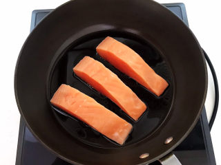 6、红烧三文鱼,炒锅烧热后加入玉米油，油烧热后加入三文鱼，全程小火煎制，先煎鱼皮，把鱼皮煎至焦黄