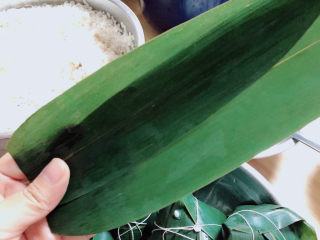 5、红豆粽子,选取两片粽叶，小一些的放在内侧。