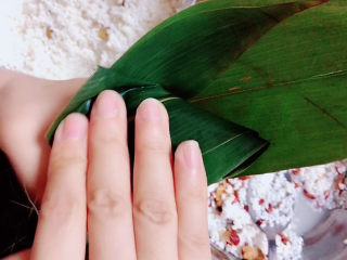 8、红豆粽子,米放满后，将粽叶盖上。