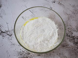 5、红糖姜汁丸子,把糯米粉边加入到姜汁中边搅拌