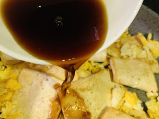 16、豆腐炒鸡蛋,把调好的料汁倒入锅里,翻拌均匀;