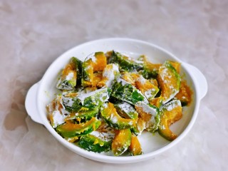 9、蛋黄南瓜,淋干后装盘，撒上一层淀粉，抓拌均匀。